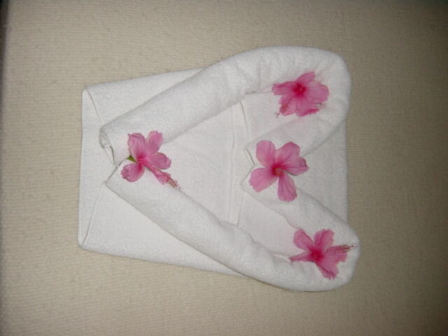 Heart-shaped towels on bed