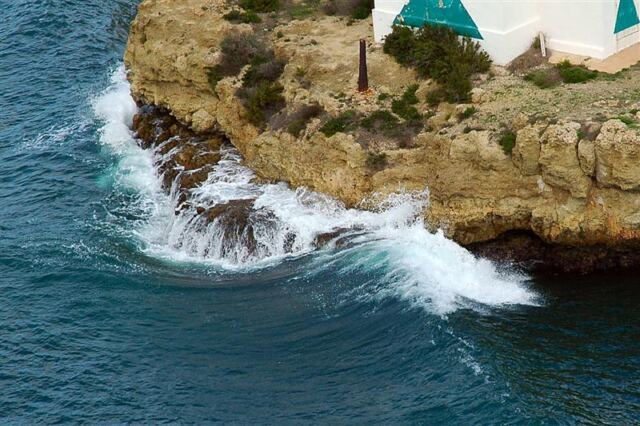 Waves crash as we pass