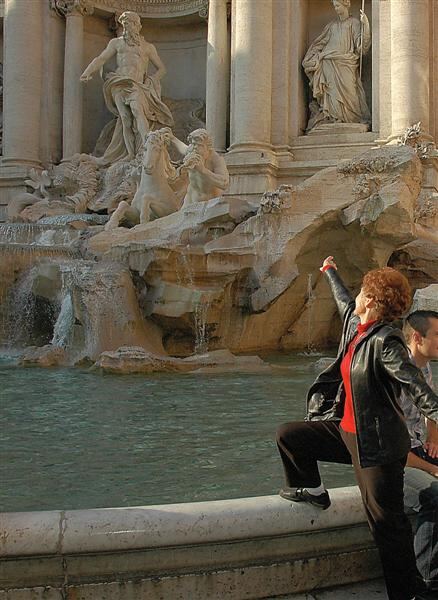 Geri tosses a coin into the Trevi Fountain
