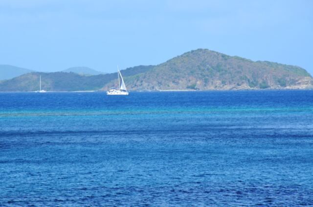 Sailboat in the blue waters of Mahoe Bay