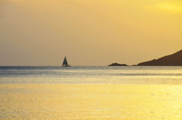 Sailboat at sunset across Mahoe Bay