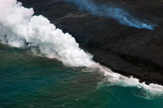 Steam rises as lava pours into water