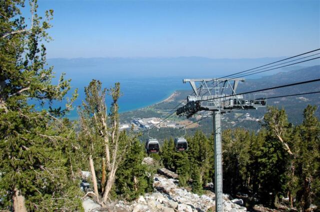 Gondolas coming up the mountain with Lake Tahoe in the background