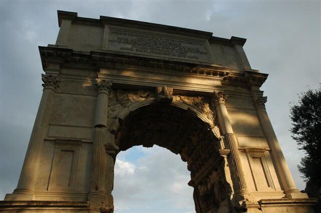 The Sun breaks through the clouds onto the Arch of Titus